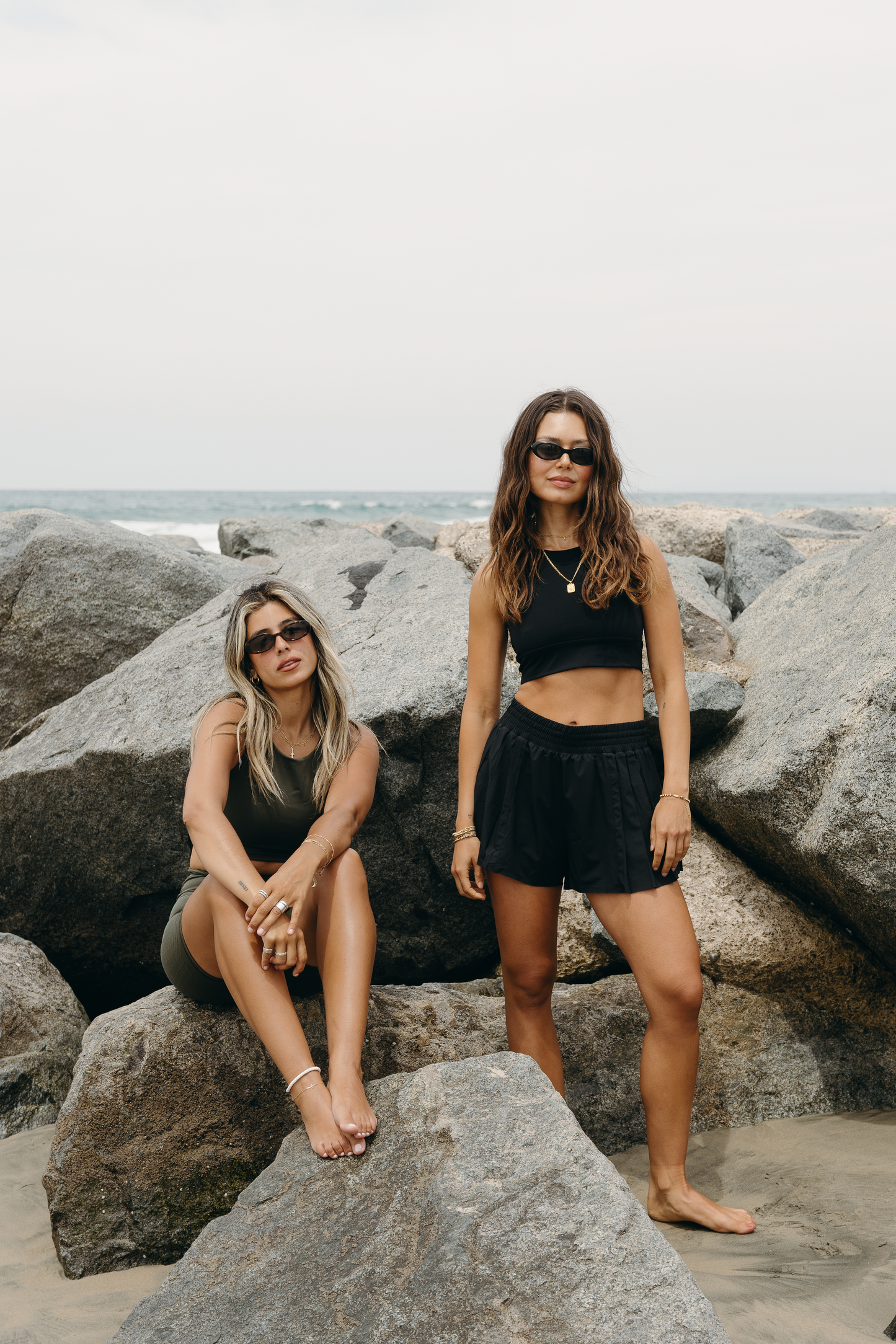 Model wearing L’Original Flowy Short featuring a featherlight pleated outer layer and a sculpting compressive inner short. The 2-in-1 design blends feminine movement with performance support, including patented MicroPerle® bead infusion and a hidden inner pocket for essentials like a phone or tennis ball.