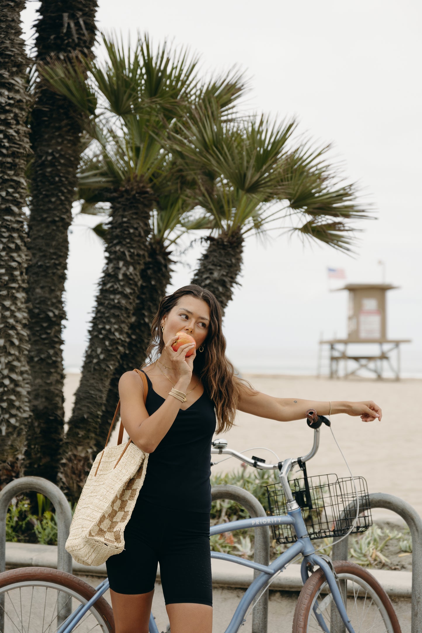 Model wearing the black Iconic Tank in a sculpting, compressive fit with an elevated neckline and built-in bra. Designed with MicroPerle® beads along the back panel for lymphatic stimulation and posture support, this sleek tank transitions effortlessly from activewear to refined layering piece.