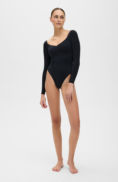 The Iconic Lisse Long Sleeve Bodysuit - Thong in black. Designed to enhance circulation, provide gentle compression, and sculpt effortlessly with OEKO-tex certified compression fabric.