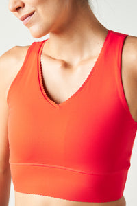 Adorn bra in poppy red color featuring an elegant scallop trim, crafted from OEKO-TEX® certified compression fabric with Elastique’s MicroPerle® technology to promote lymphatic drainage, improve circulation, and reduce fatigue.