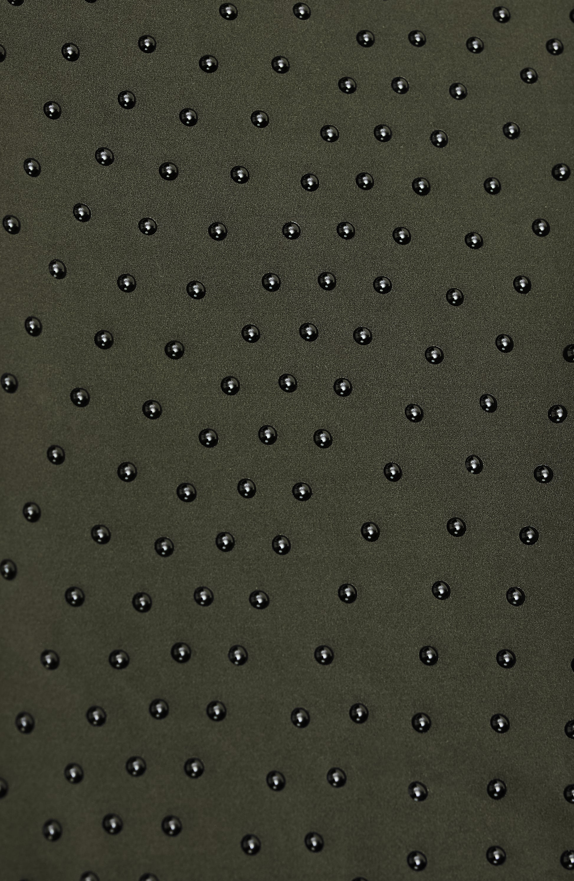 Close-up of Elastique’s MicroPerle® technology in olive green compression fabric, showing the textured microbeads designed to stimulate lymphatic drainage, improve circulation, and smooth the skin.