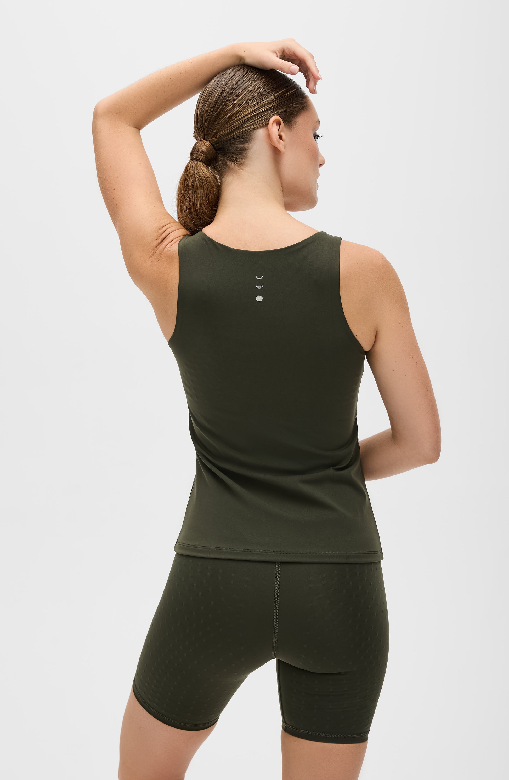 Model wearing the L’Original tank in olive green, made from OEKO-TEX® certified compression fabric featuring MicroPerle® technology along the back to promote lymphatic drainage, improve circulation, and reduce fatigue.