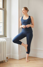 Model wearing the L’Original tank in navy blue, made from OEKO-TEX® certified compression fabric featuring MicroPerle® technology along the back to promote lymphatic drainage, improve circulation, and reduce fatigue.