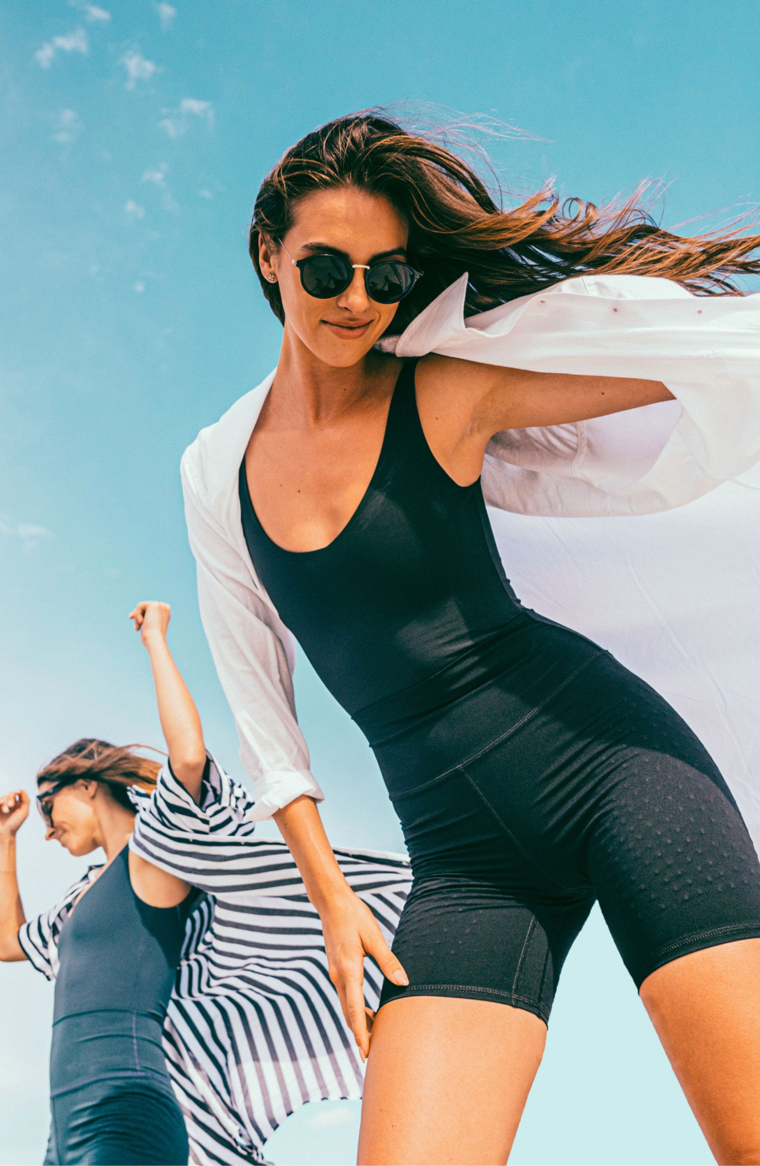 Models wearing the L’Original Bike Short in navy, made from OEKO-TEX® certified compression fabric featuring Elastique’s MicroPerle® technology to promote lymphatic drainage, enhance circulation, reduce fatigue, and smooth the skin.