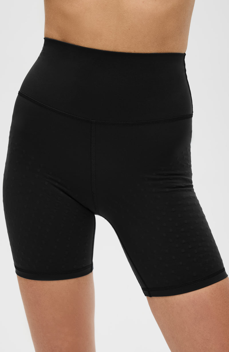 Model wearing the L’Original Bike Short in Black, made from OEKO-TEX® certified compression fabric featuring Elastique’s MicroPerle® technology to promote lymphatic drainage, enhance circulation, reduce fatigue, and smooth the skin.