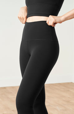 Model wearing the Lisse leggings with matching bra in black, crafted from OEKO-TEX® certified compression fabric designed to sculpt the silhouette, enhance circulation, and deliver a smooth, second-skin feel.