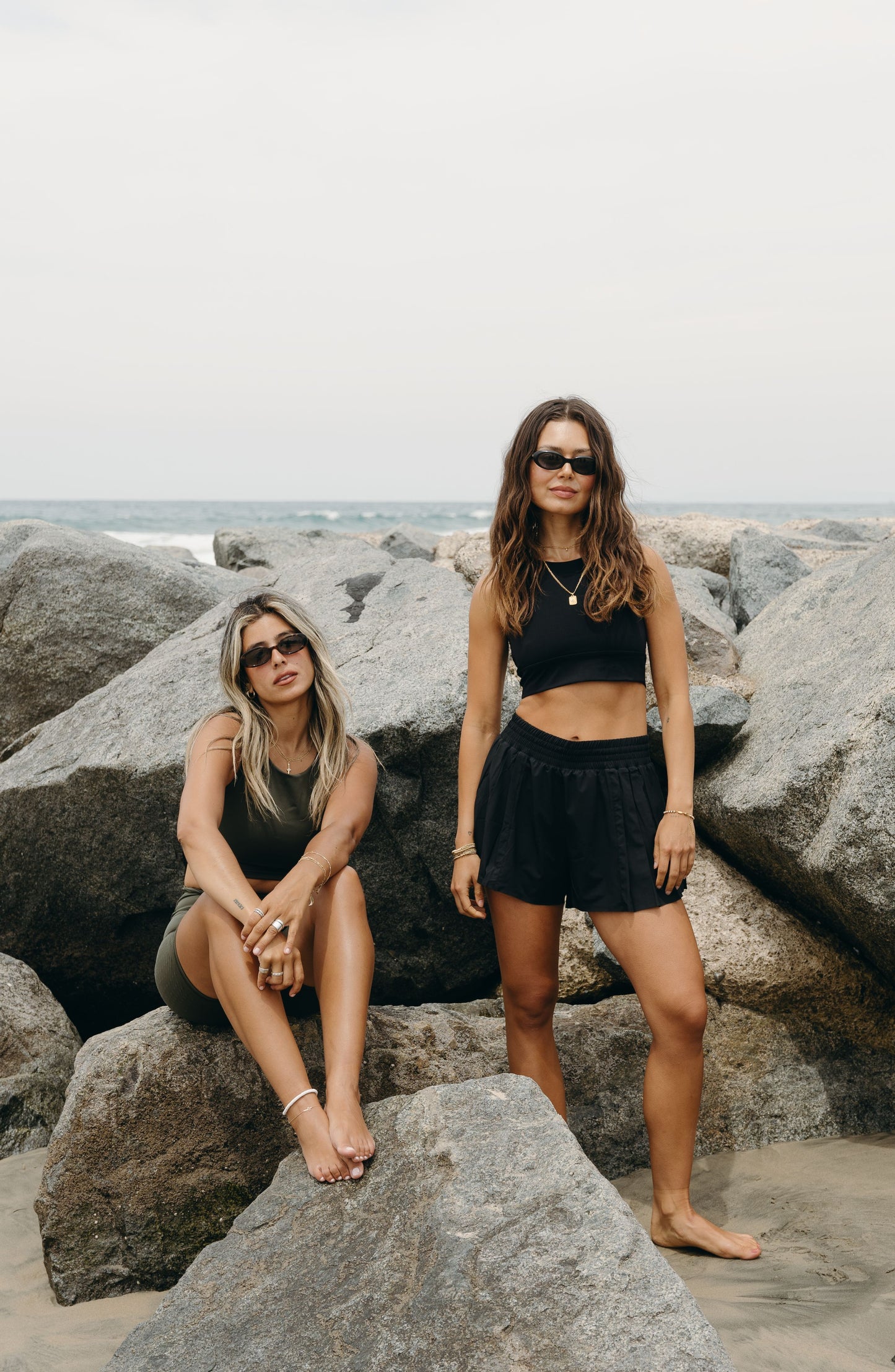 Model wearing L’Original Flowy Short featuring a featherlight pleated outer layer and a sculpting compressive inner short. The 2-in-1 design blends feminine movement with performance support, including patented MicroPerle® bead infusion and a hidden inner pocket for essentials like a phone or tennis ball.