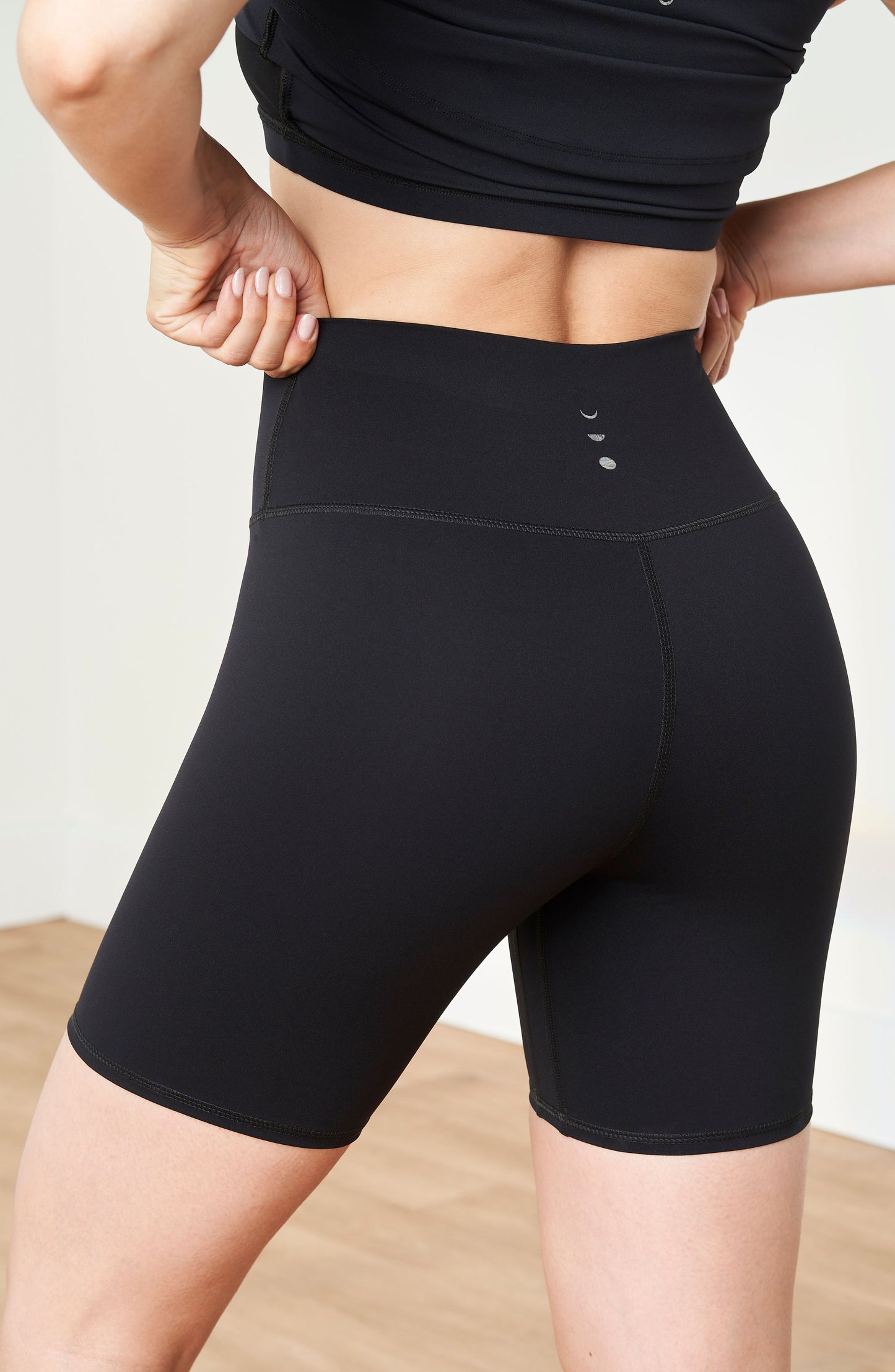 Model wearing the Lisse bike short in black, made from OEKO-TEX® certified compression fabric designed to smooth, sculpt, and support the body for optimal comfort and circulation.