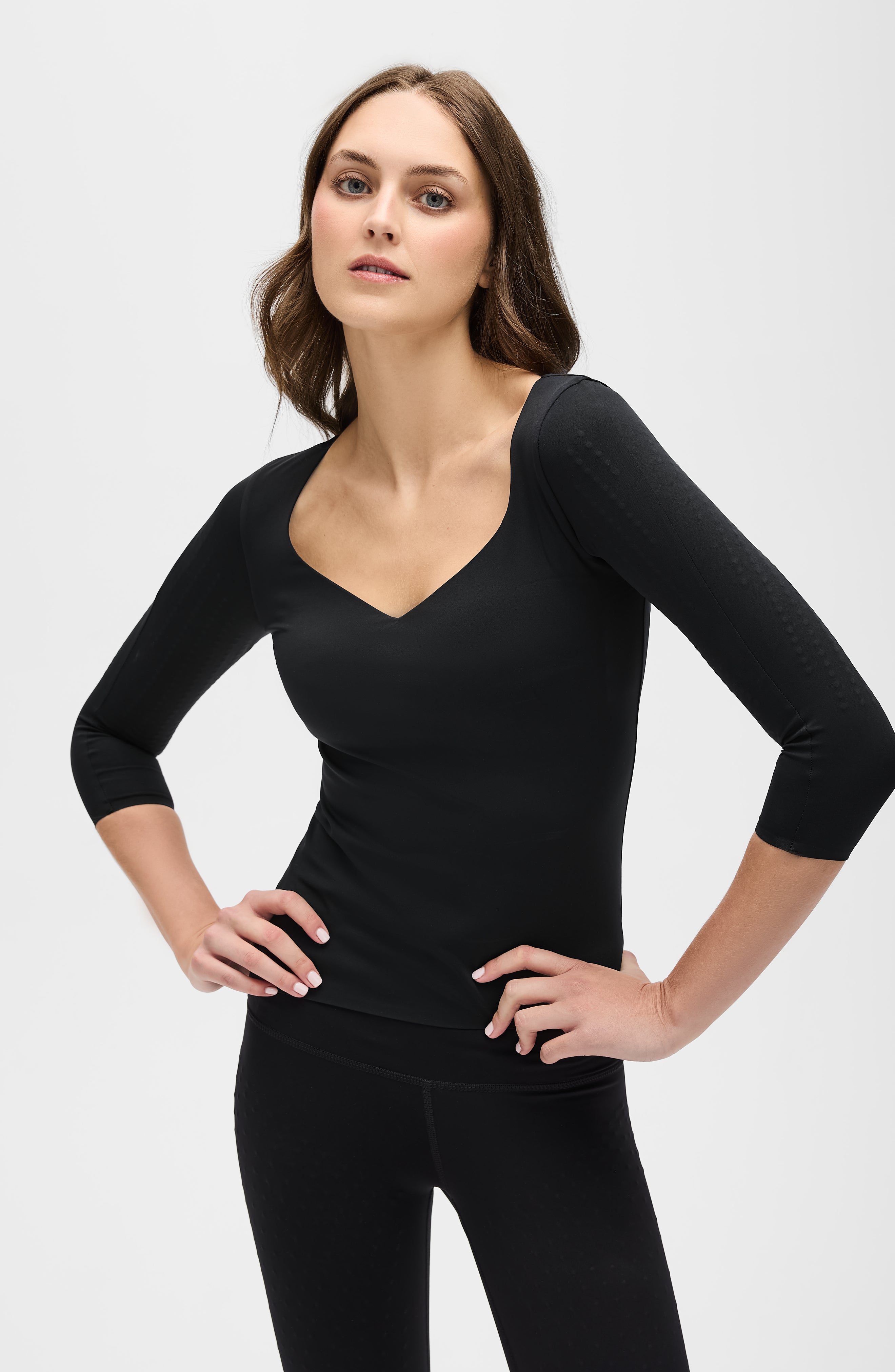 Iconic 3/4 Sleeve MicroPerle® top in black featuring MicroPerle® bead panels on the upper arms and back, designed to boost the lymphatic system, improve circulation, and smooth the skin with OEKO-TEX® certified compression fabric.
