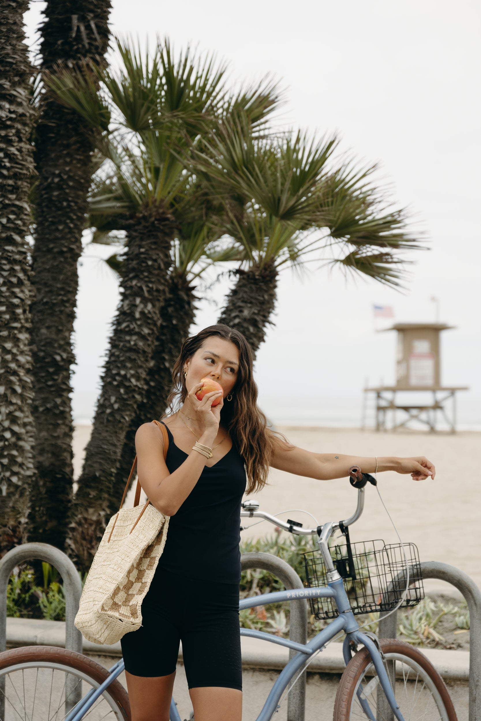 Model wearing the black Iconic Tank in a sculpting, compressive fit with an elevated neckline and built-in bra. Designed with MicroPerle® beads along the back panel for lymphatic stimulation and posture support, this sleek tank transitions effortlessly from activewear to refined layering piece.