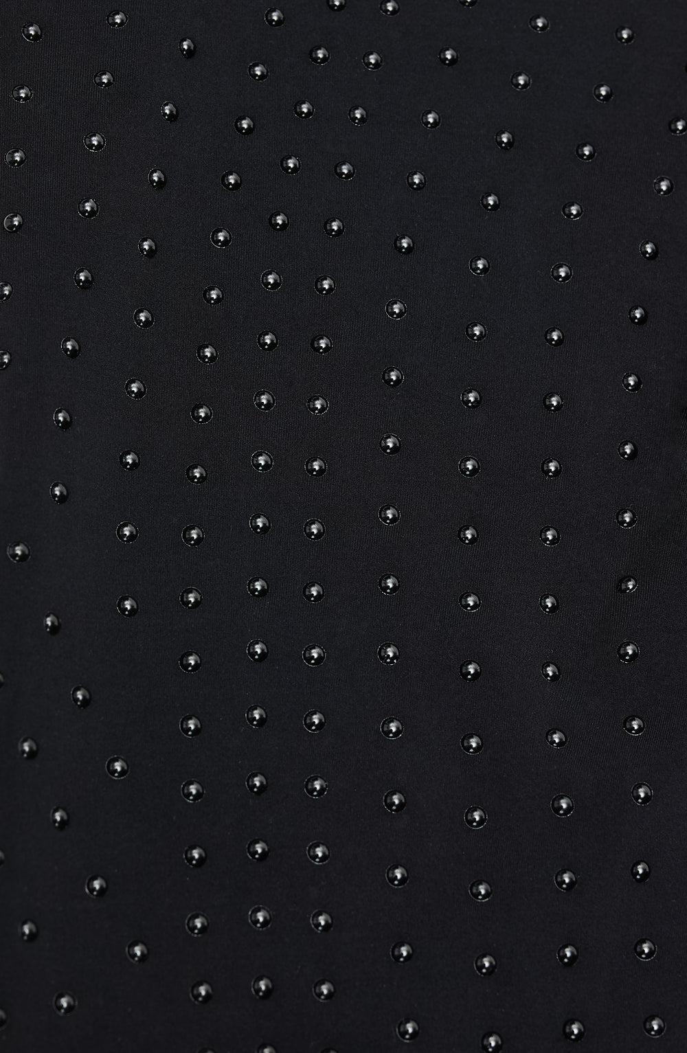 Close-up of Elastique’s MicroPerle® technology on black compression fabric, showing the textured microbeads designed to stimulate lymphatic drainage, improve circulation, and smooth the skin.