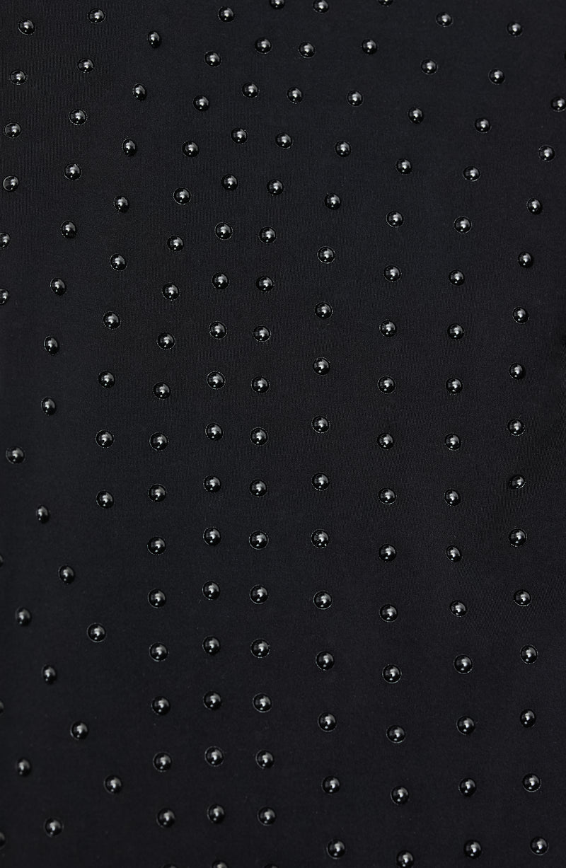 Close-up of Elastique’s MicroPerle® technology on black compression fabric, showing the textured microbeads designed to stimulate lymphatic drainage, improve circulation, and smooth the skin.