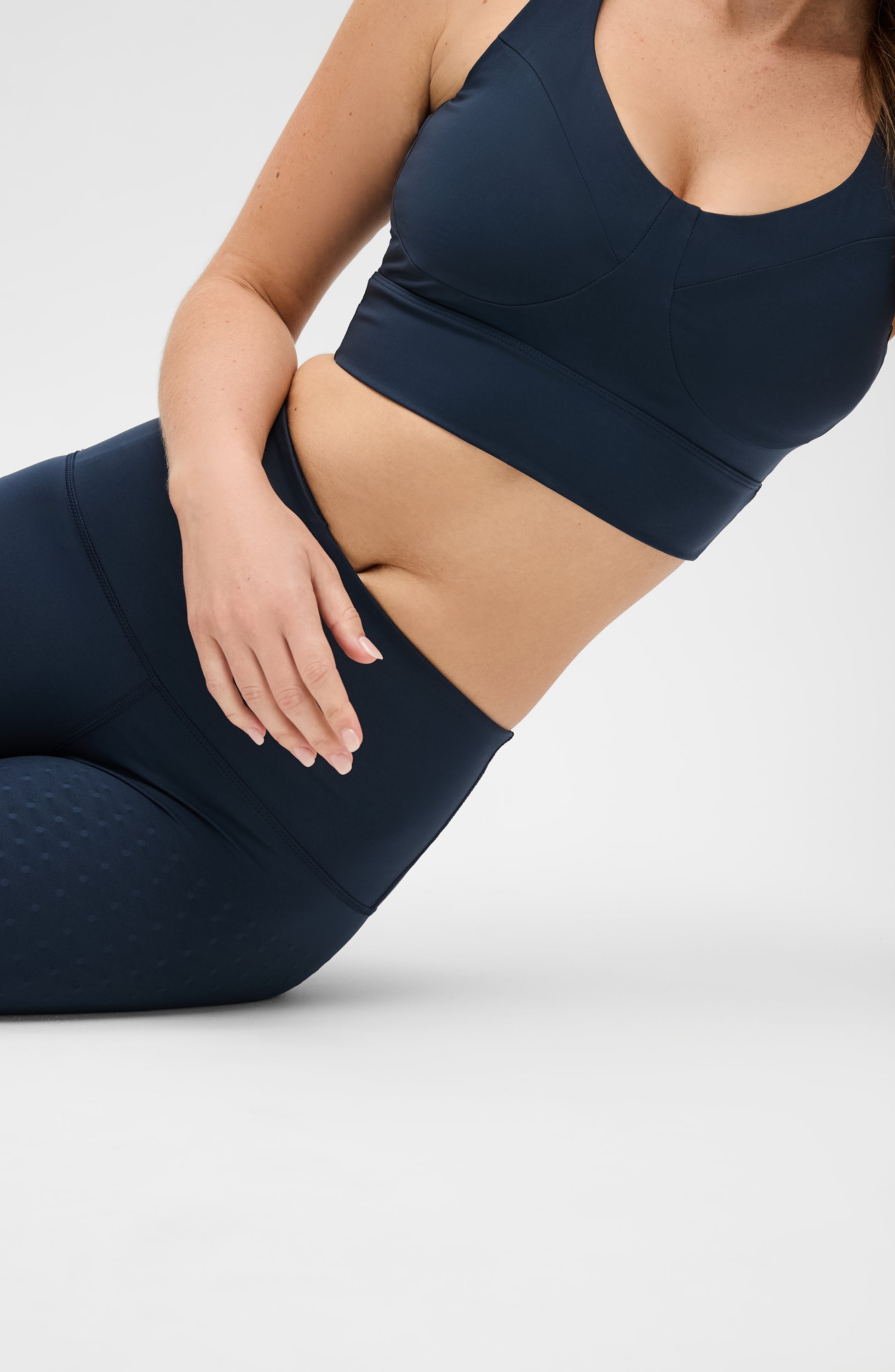 Model wearing the Le Divine bra in navy blue, made from OEKO-TEX® certified compression fabric with Elastique’s MicroPerle® technology to enhance circulation, promote lymphatic drainage, and relieve pain.