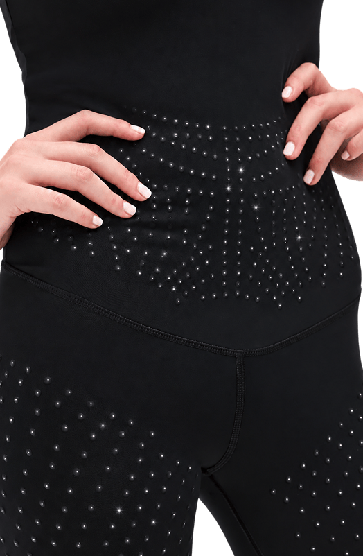 Close-up of a person wearing black leggings with micro pearl beads on torso and upper thighs, shown against a plain white background.