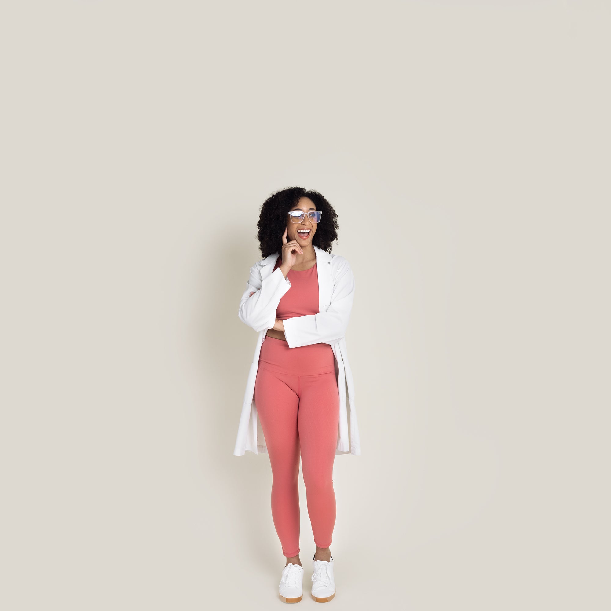 Model posing in Desert Rose compression activewear set wearing white lab coat and glasses