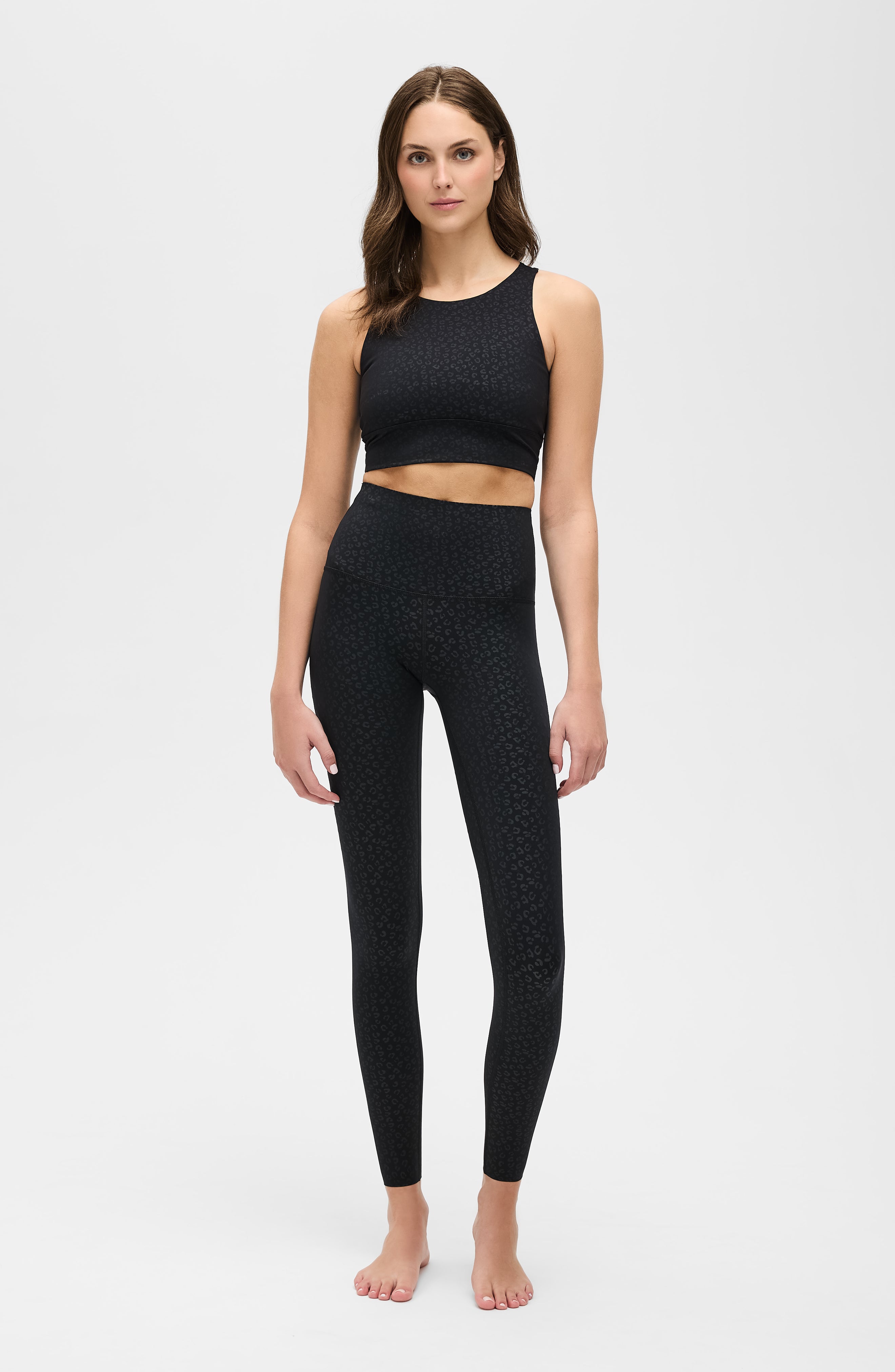 Model wearing The Fierce leggings and bra in black with cheetah print, made from OEKO-TEX® certified compression fabric featuring Elastique’s MicroPerle® technology to enhance lymphatic drainage, improve circulation, reduce fatigue, and smooth the skin.