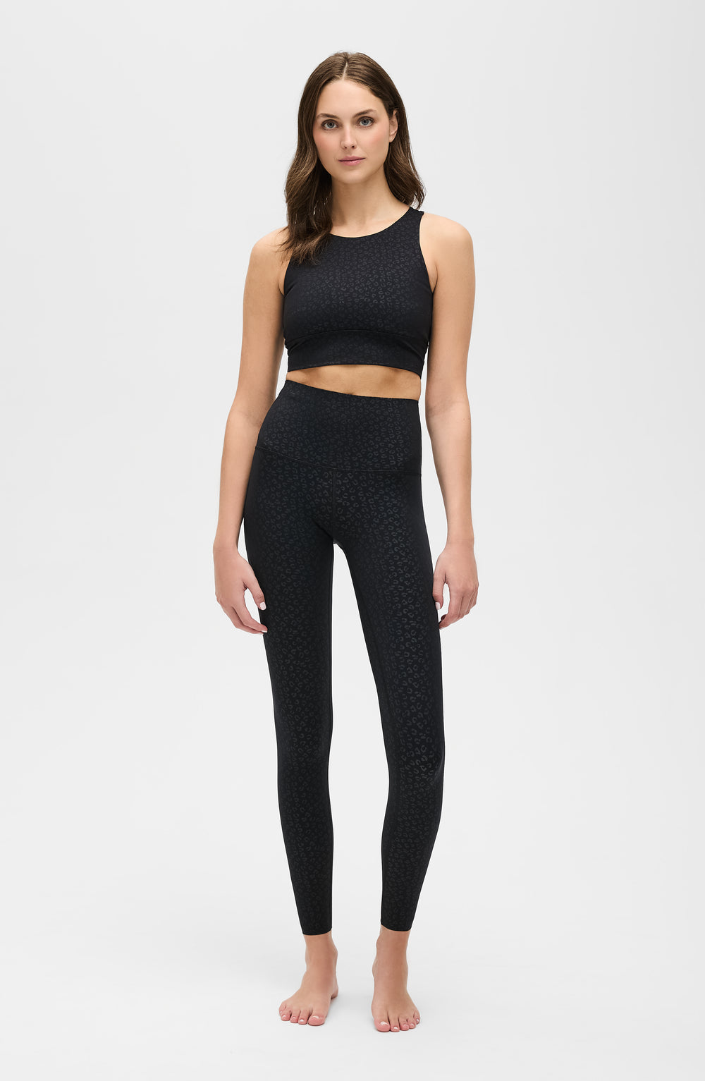 Model wearing The Fierce leggings and bra in black with cheetah print, made from OEKO-TEX® certified compression fabric featuring Elastique’s MicroPerle® technology to enhance lymphatic drainage, improve circulation, reduce fatigue, and smooth the skin.