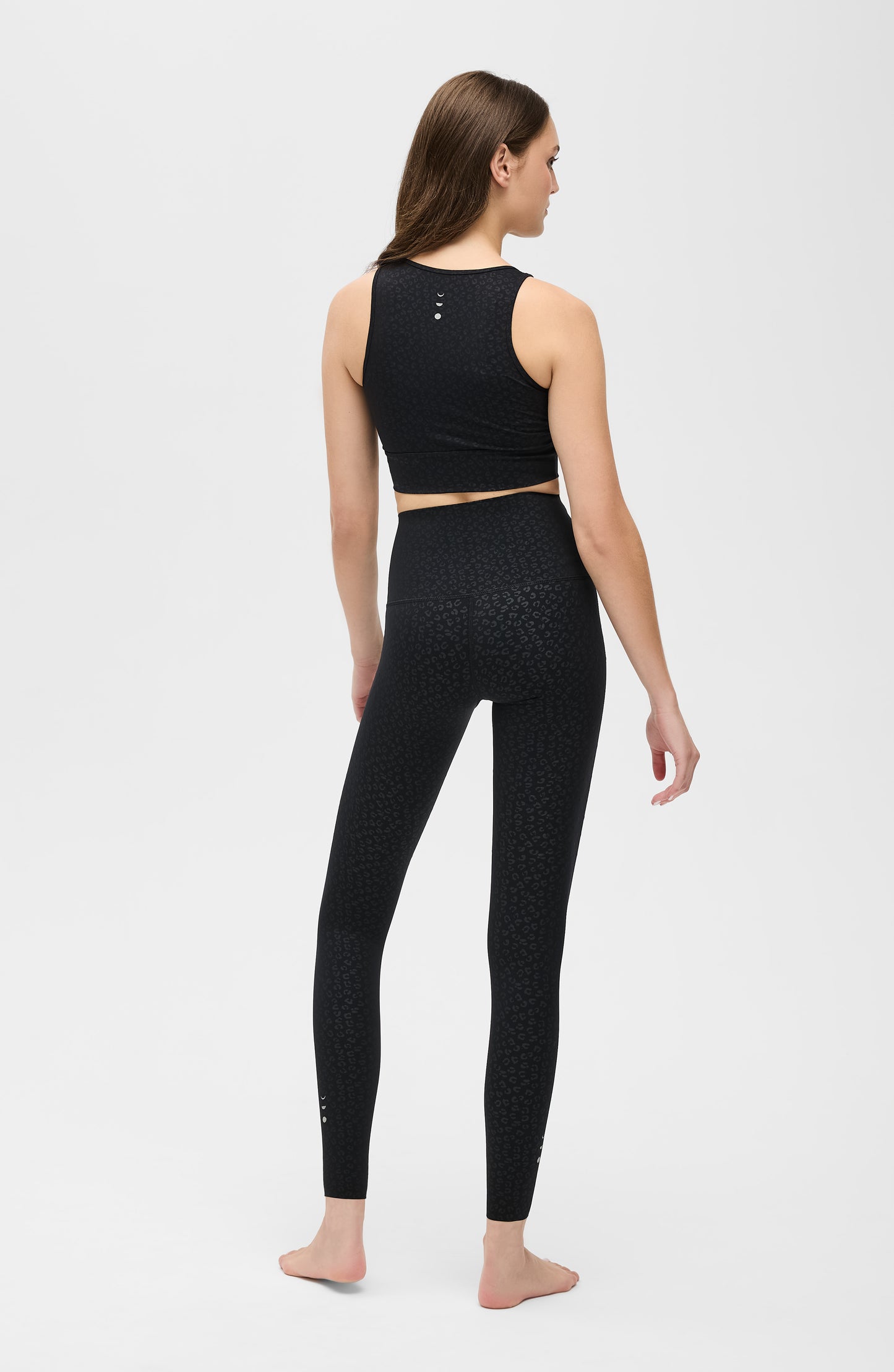 Model wearing The Fierce leggings and bra in black with cheetah print, made from OEKO-TEX® certified compression fabric featuring Elastique’s MicroPerle® technology to enhance lymphatic drainage, improve circulation, reduce fatigue, and smooth the skin.
