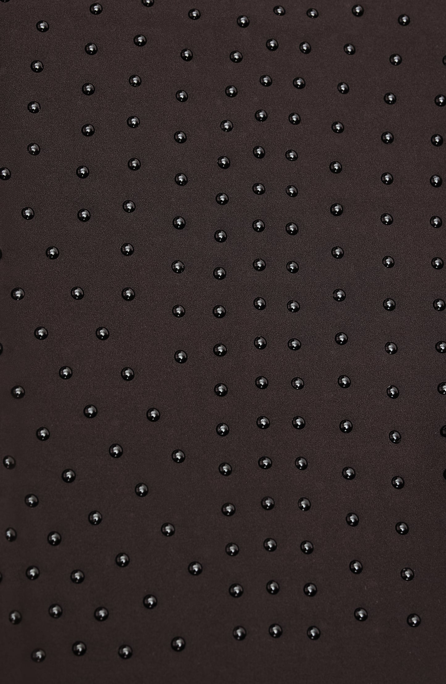 Close-up of Elastique’s MicroPerle® technology in java brown compression fabric, showing the textured microbeads designed to stimulate lymphatic drainage, improve circulation, and smooth the skin.