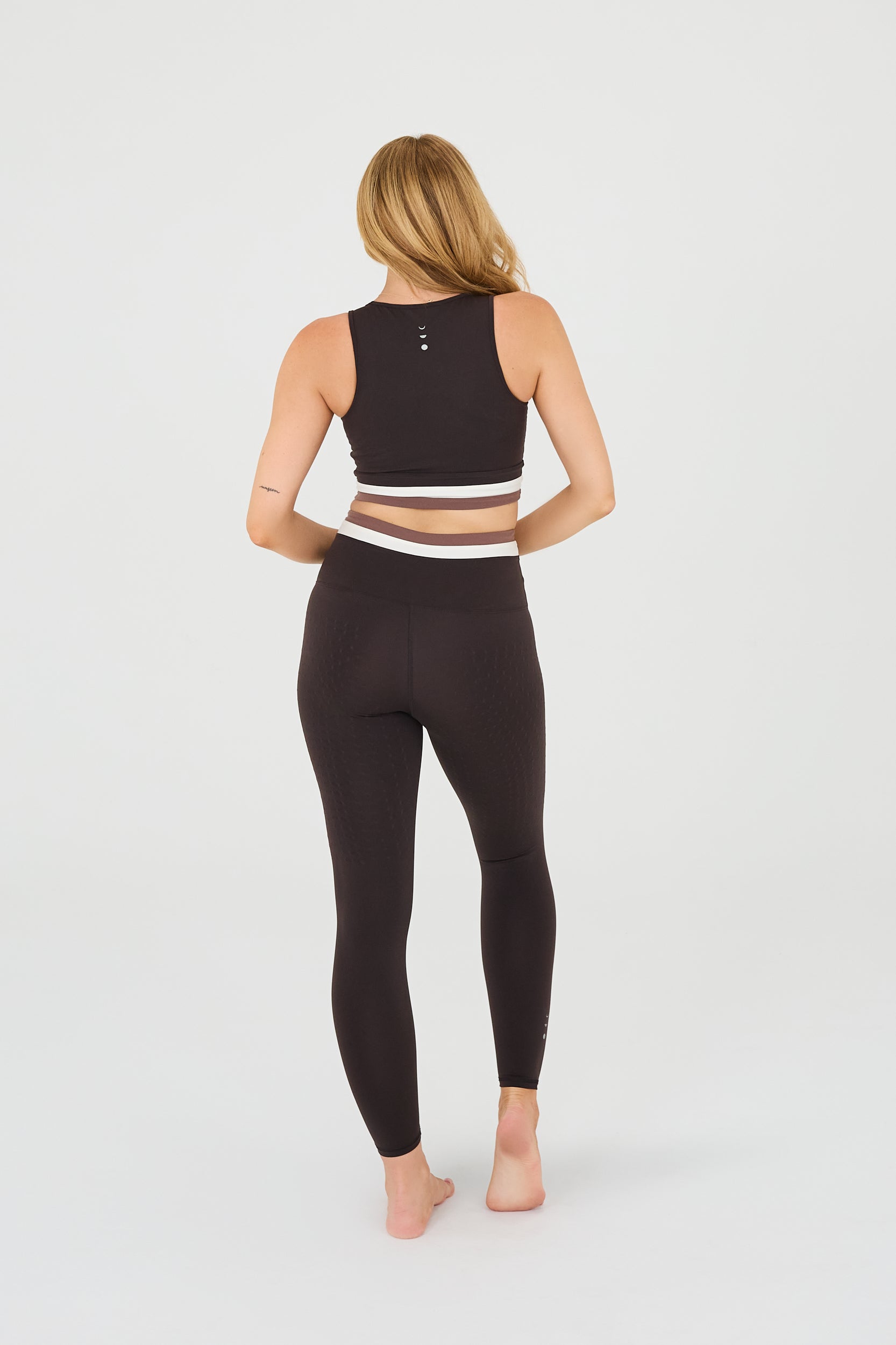 back photo: Le Monde leggings and bra in Java, Ivory, and Cappuccino colors made from OEKO-TEX® certified compression fabric featuring Elastique’s MicroPerle® technology to promote lymphatic drainage, improve circulation, reduce fatigue, and smooth the skin.