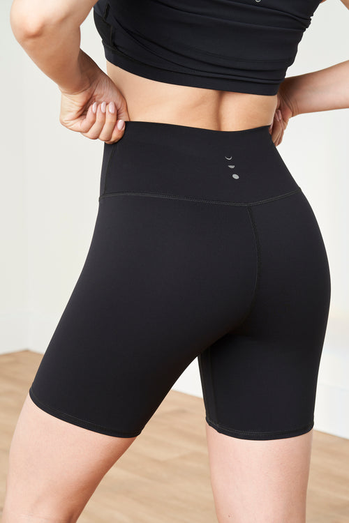 Load image 1 in gallery view. Model wearing the Lisse bike short in black, made from OEKO-TEX® certified compression fabric designed to smooth, sculpt, and support the body for optimal comfort and circulation.