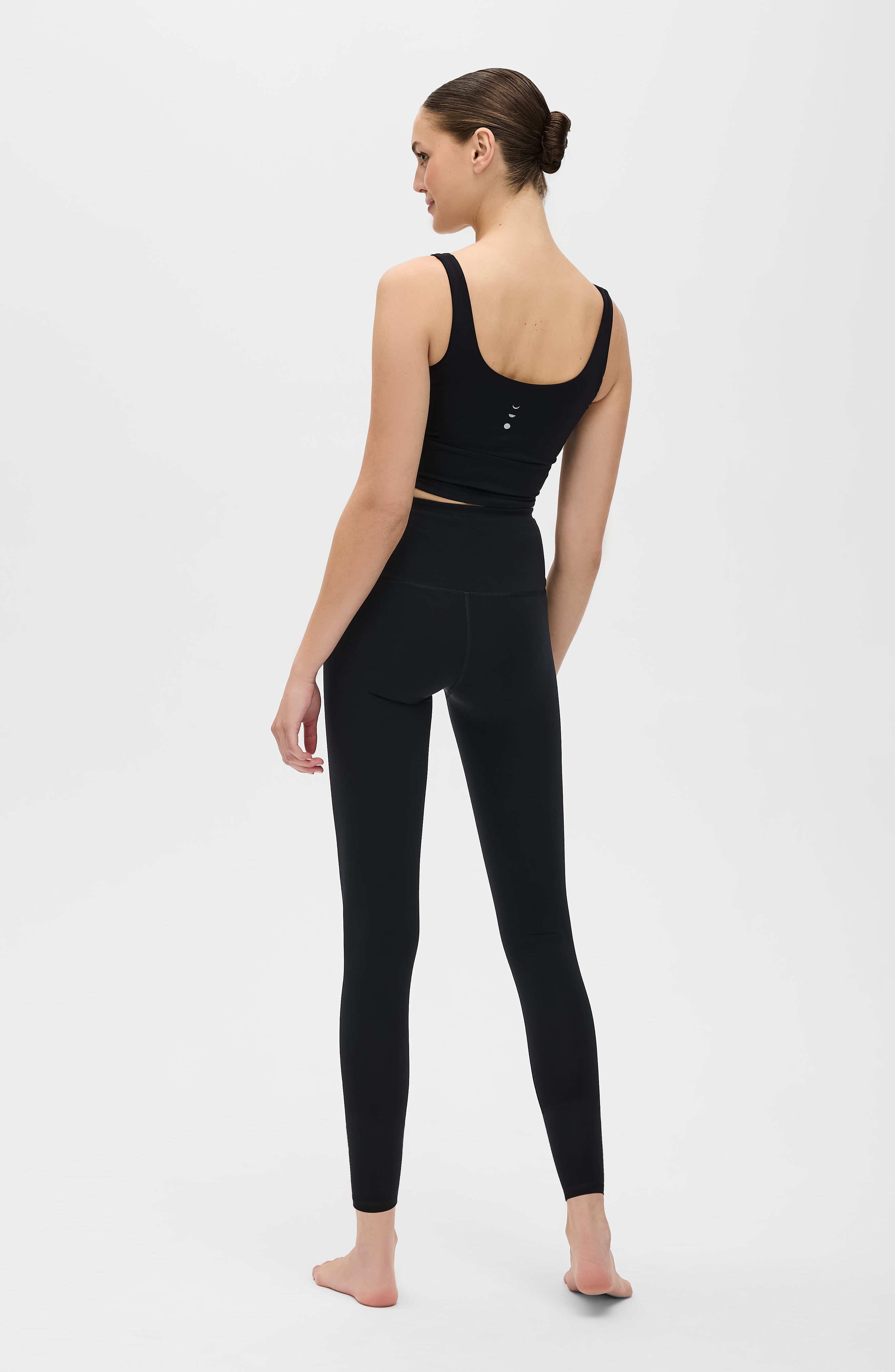 Model wearing the Lisse leggings with matching bra in black, crafted from OEKO-TEX® certified compression fabric designed to sculpt the silhouette, enhance circulation, and deliver a smooth, second-skin feel.