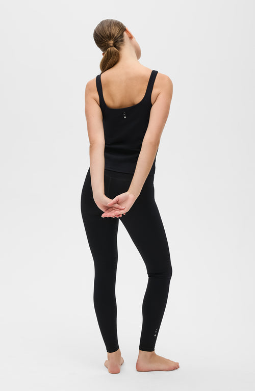 Load image 1 in gallery view. Model wearing the Lisse leggings with matching tank in black, crafted from OEKO-TEX® certified compression fabric designed to sculpt the silhouette, enhance circulation, and deliver a smooth, second-skin feel.