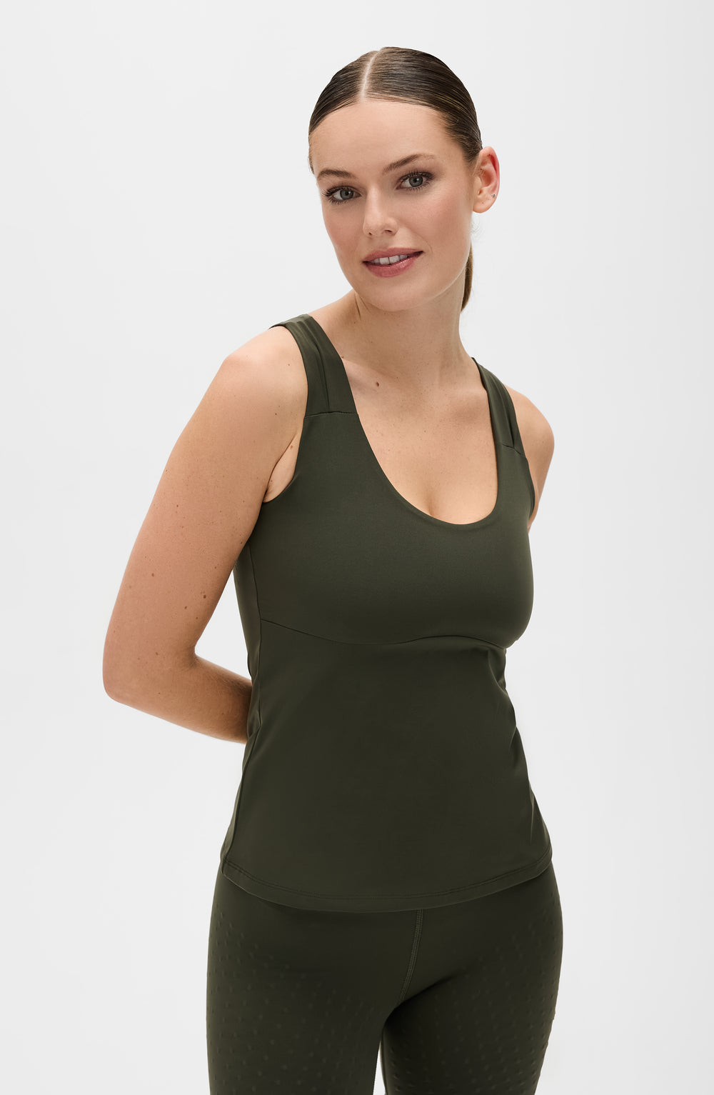 Model wearing the L’Original leggings and tank in olive green color, made from OEKO-TEX® certified compression fabric featuring MicroPerle® technology along the back to promote lymphatic drainage, improve circulation, and reduce fatigue.