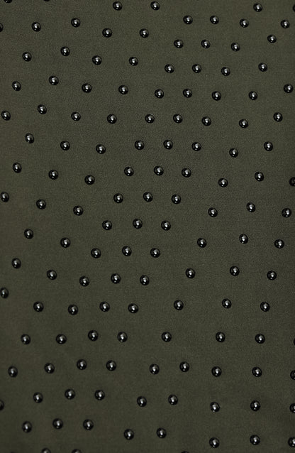 Close-up of Elastique’s MicroPerle® technology in olive green compression fabric, showing the textured microbeads designed to stimulate lymphatic drainage, improve circulation, and smooth the skin.