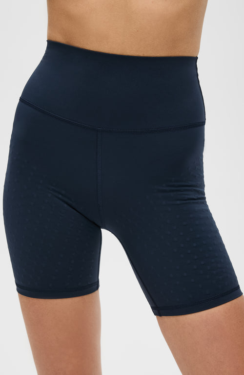 Load image 1 in gallery view. Model wearing the L’Original Bike Short in navy blue, made from OEKO-TEX® certified compression fabric featuring Elastique’s MicroPerle® technology to promote lymphatic drainage, enhance circulation, reduce fatigue, and smooth the skin.