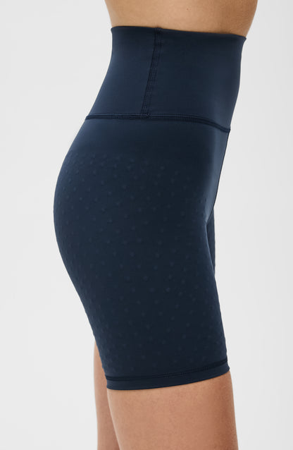 Model wearing the L’Original Bike Short in navy blue, made from OEKO-TEX® certified compression fabric featuring Elastique’s MicroPerle® technology to promote lymphatic drainage, enhance circulation, reduce fatigue, and smooth the skin.