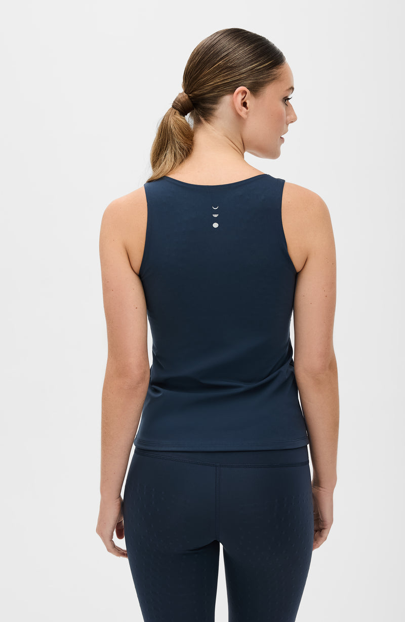 Model wearing the L’Original leggings and tank in navy blue, made from OEKO-TEX® certified compression fabric featuring MicroPerle® technology along the back to promote lymphatic drainage, improve circulation, and reduce fatigue.
