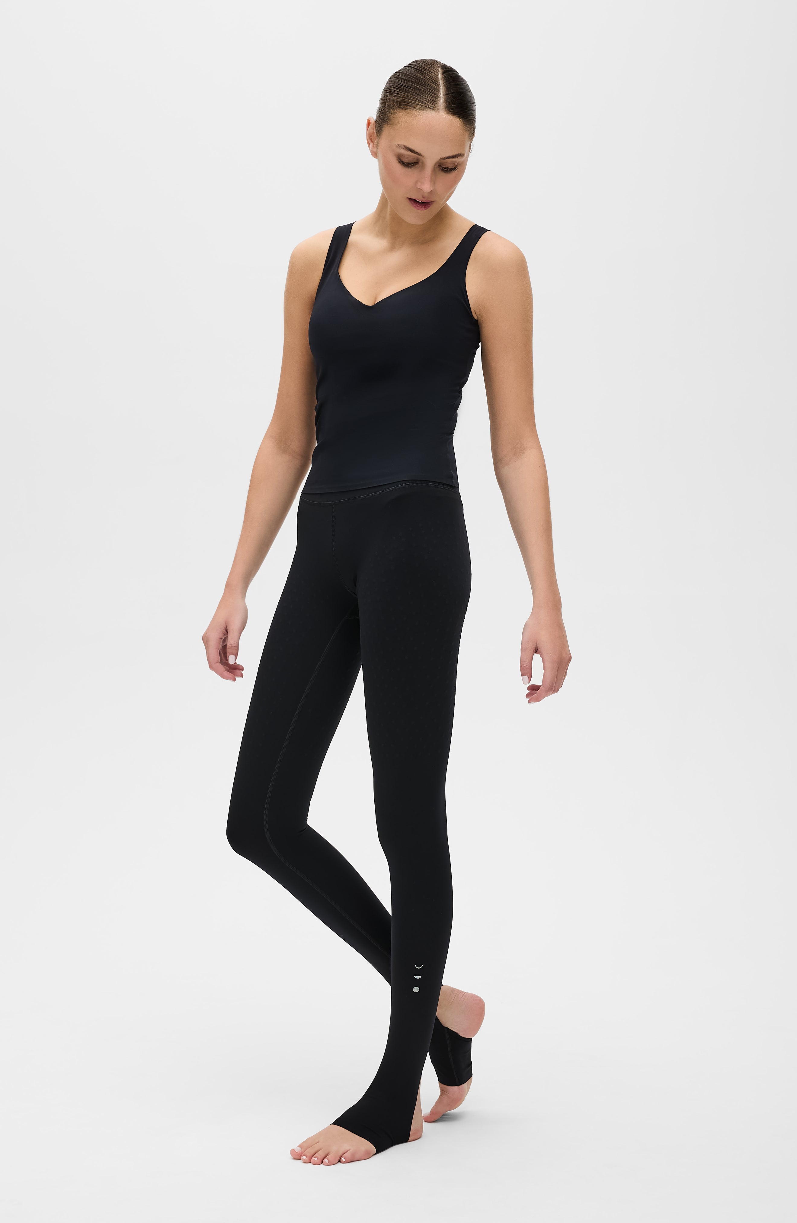 Model wearing L’Original stirrup leggings in black with Iconic MicroPerle tank featuring Elastique’s MicroPerle® technology on OEKO-TEX® certified compression fabric to enhance circulation, support lymphatic drainage, and provide pain relief.